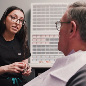 Hi-Fidelity Dental doctor explaining a procedure to an elderly man in a dental chair