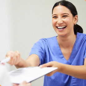 Hi-Fidelity Dental happy dental assistant handing a form to a patient